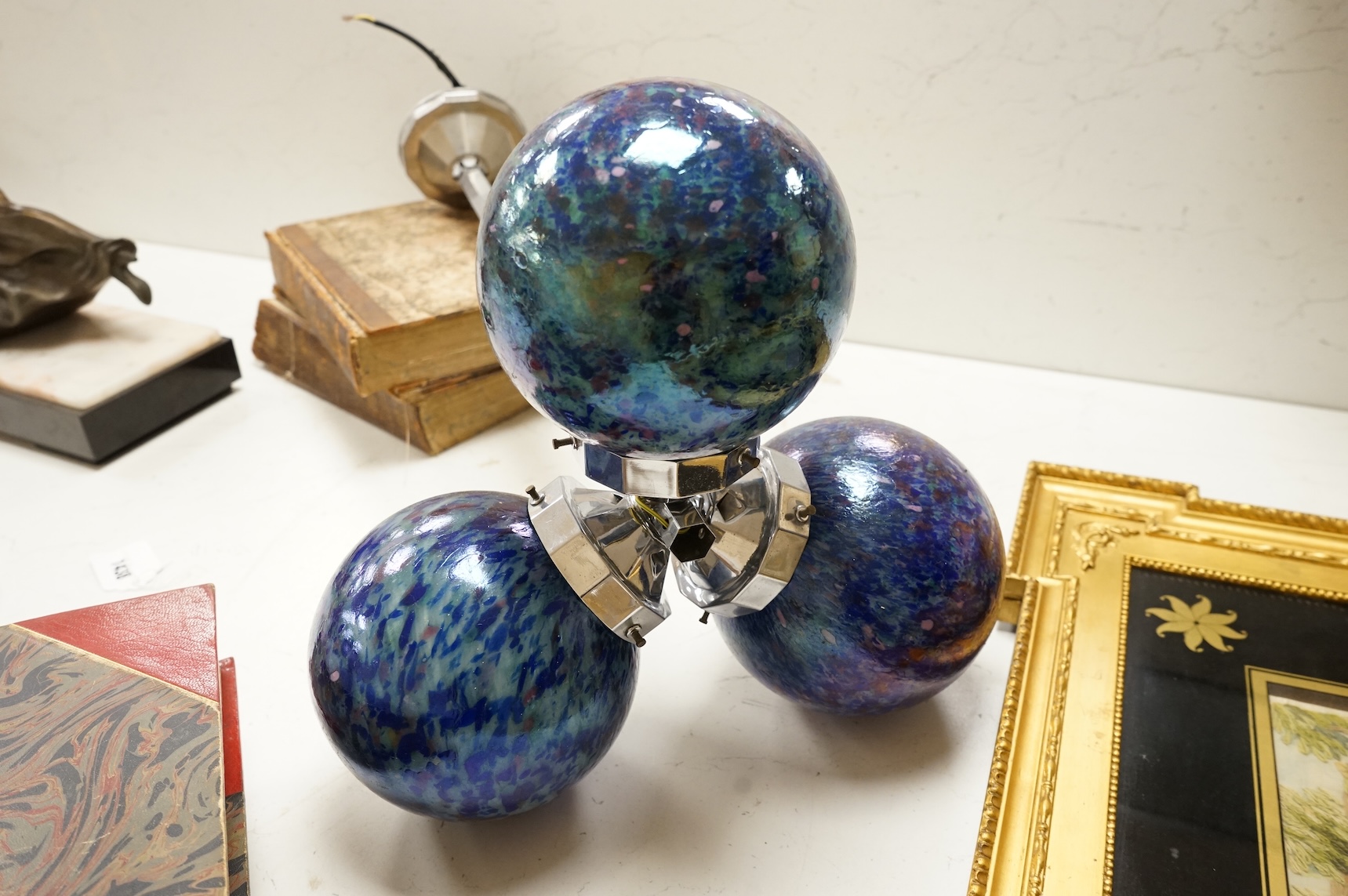 A French Art Deco chromed metal triple glass globed pendant ceiling light, 63cm high